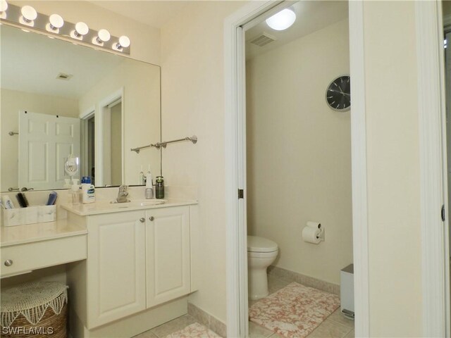 bathroom with tile patterned flooring, vanity, and toilet