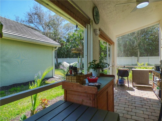 sunroom / solarium featuring ceiling fan