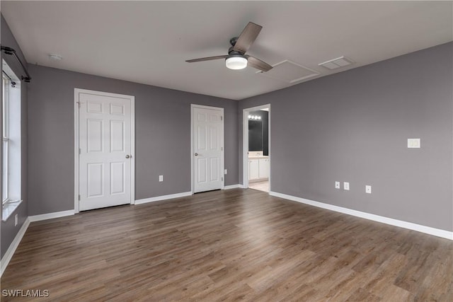 unfurnished bedroom with ensuite bath, ceiling fan, and wood-type flooring