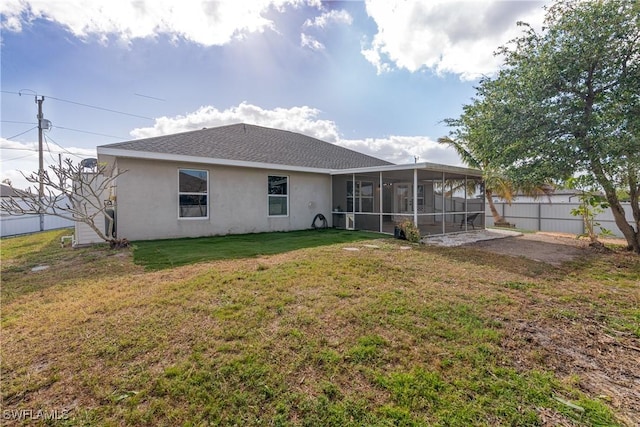 back of property featuring a sunroom and a yard