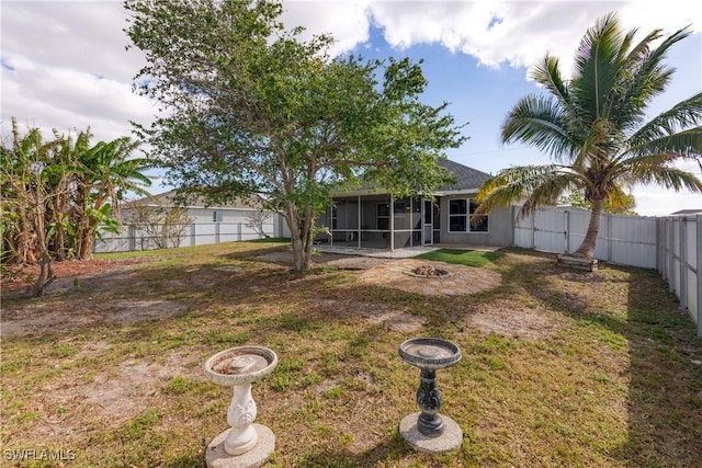 view of yard featuring a sunroom and an outdoor fire pit