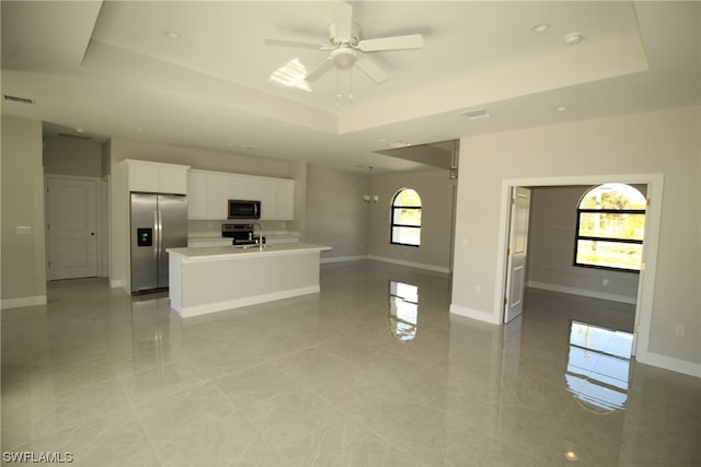 kitchen featuring a wealth of natural light, appliances with stainless steel finishes, and a tray ceiling