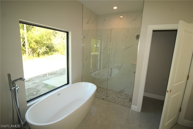 bathroom featuring independent shower and bath and tile flooring