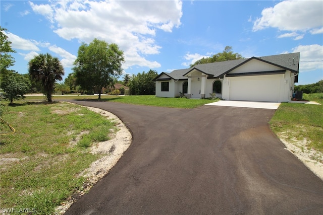 ranch-style house featuring a front yard and a garage