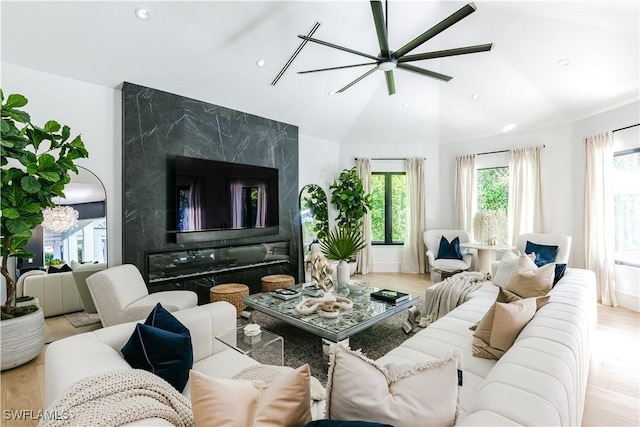 living area with recessed lighting, lofted ceiling, a ceiling fan, and wood finished floors