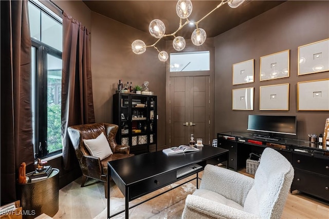 office area with light wood-style flooring and a chandelier