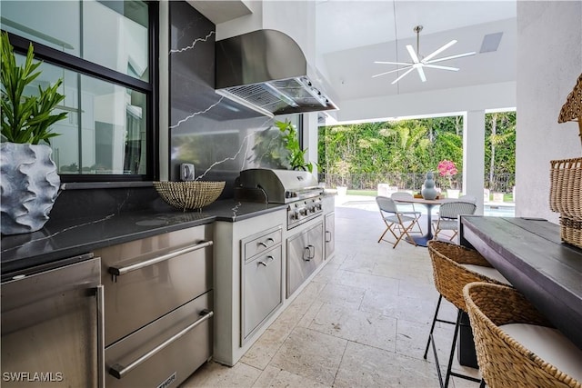 view of patio featuring a ceiling fan, fence, grilling area, outdoor dining area, and an outdoor kitchen