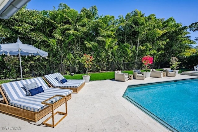 view of swimming pool with outdoor lounge area, a fenced in pool, a patio area, and fence