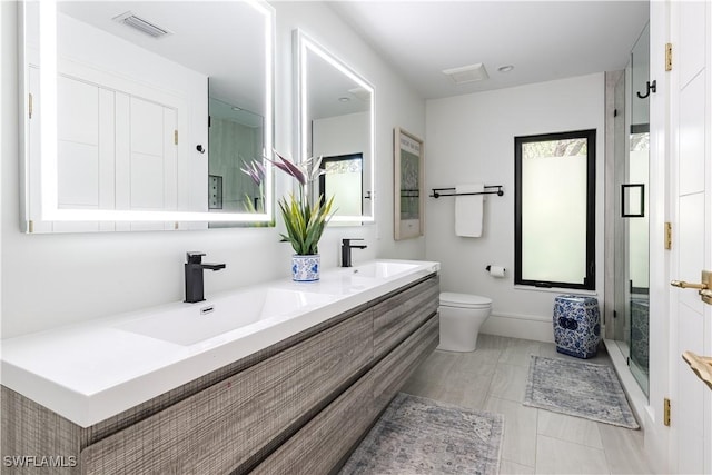 full bath with double vanity, visible vents, toilet, and a sink