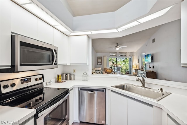 kitchen featuring ceiling fan, kitchen peninsula, appliances with stainless steel finishes, white cabinets, and sink