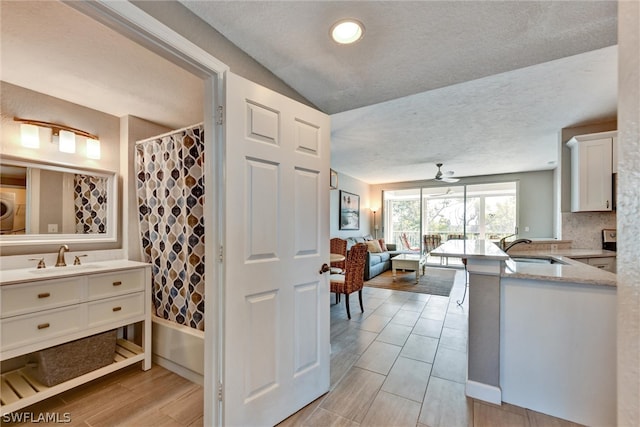 interior space featuring sink, vaulted ceiling, and washer / clothes dryer