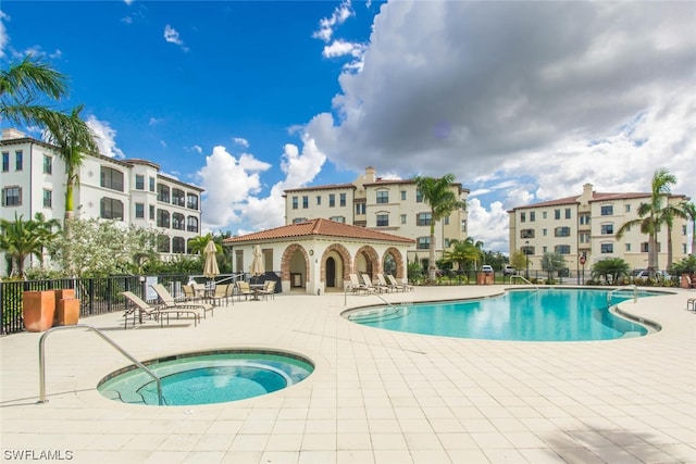 view of swimming pool with a hot tub and a patio area