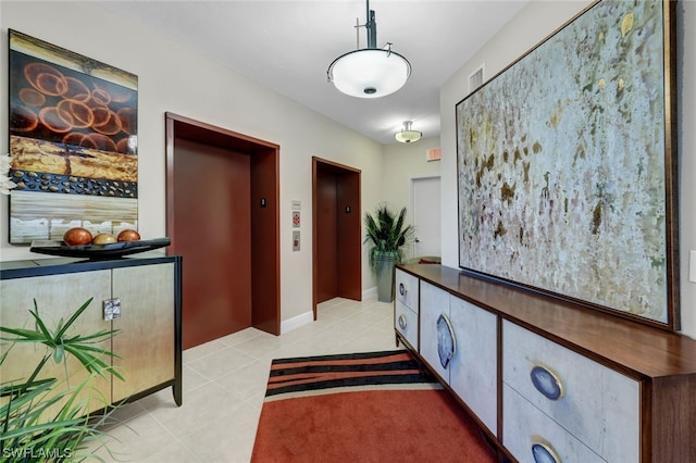 hallway with elevator and light tile patterned floors