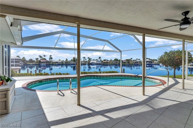 view of swimming pool with a patio, a water view, ceiling fan, and a lanai