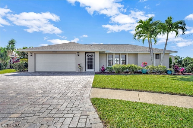 single story home featuring a garage and a front lawn