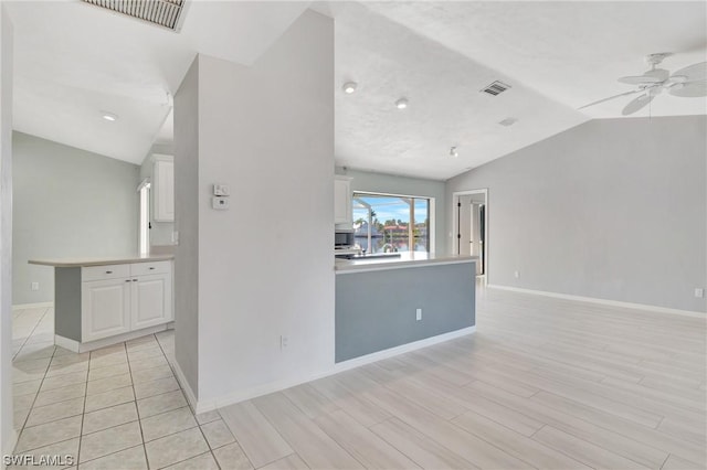 unfurnished room with ceiling fan, lofted ceiling, and light wood-type flooring