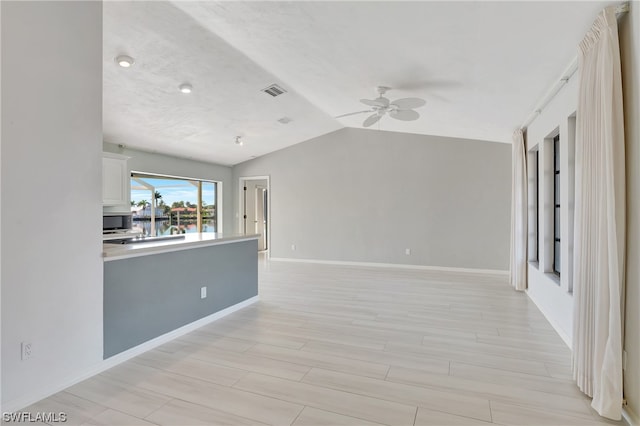 unfurnished living room featuring ceiling fan, light hardwood / wood-style floors, and vaulted ceiling