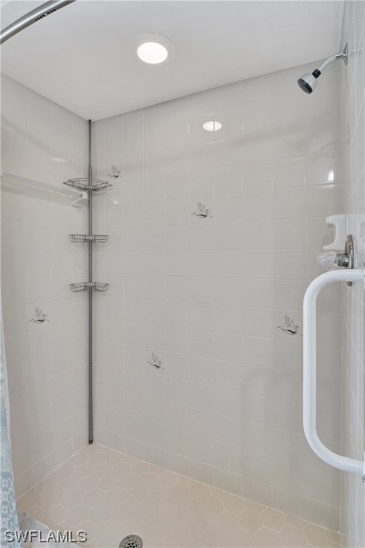 bathroom featuring tile patterned flooring and a tile shower