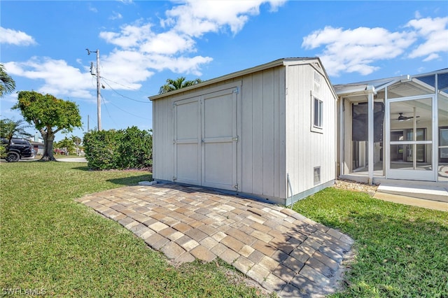 view of outbuilding with a sunroom and a lawn