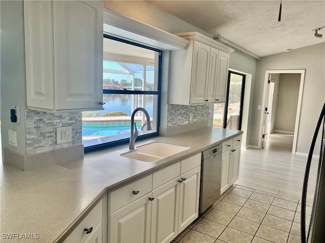 kitchen featuring white cabinets, sink, stainless steel dishwasher, plenty of natural light, and light hardwood / wood-style floors