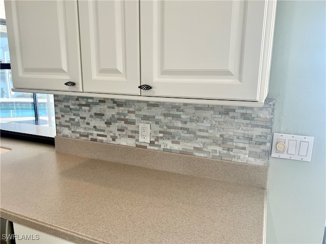 details featuring white cabinets and tasteful backsplash