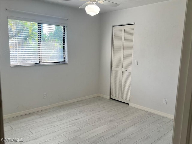 unfurnished bedroom with ceiling fan, light hardwood / wood-style floors, and a closet