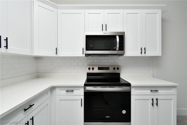 kitchen with decorative backsplash, white cabinets, and black range with electric stovetop