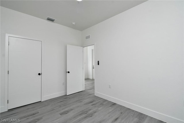 unfurnished bedroom featuring light hardwood / wood-style floors and a closet