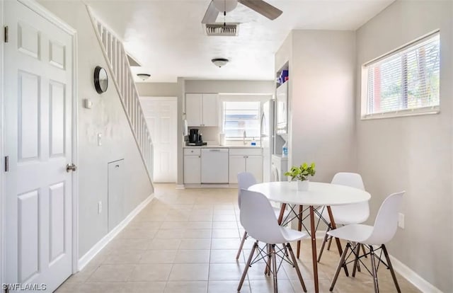 dining room featuring light tile flooring, ceiling fan, and sink