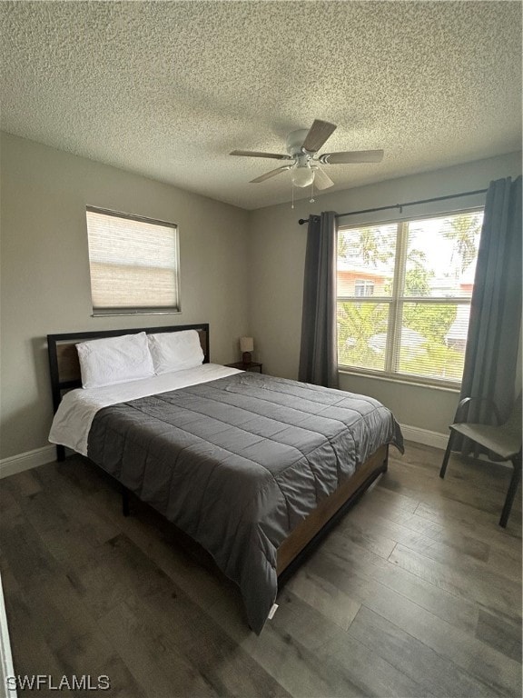 bedroom with hardwood / wood-style floors, a textured ceiling, and ceiling fan