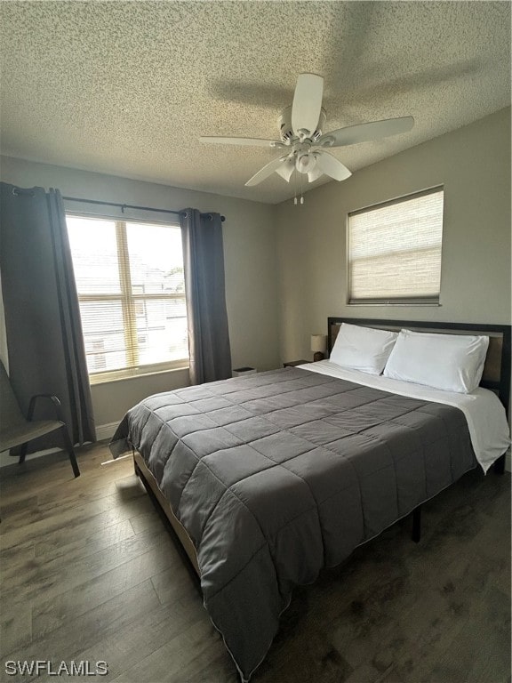 bedroom featuring dark hardwood / wood-style floors, a textured ceiling, and ceiling fan