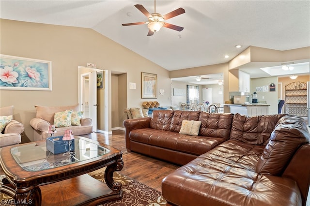 living room with ceiling fan, lofted ceiling, and dark wood-type flooring