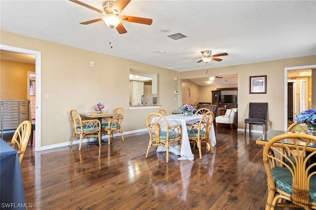 dining area featuring dark hardwood / wood-style floors, ceiling fan, and a textured ceiling