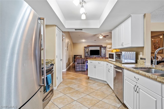 kitchen featuring light stone countertops, white cabinetry, stainless steel appliances, light tile floors, and ceiling fan