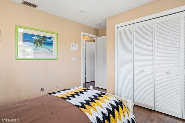 bedroom with dark hardwood / wood-style flooring and a closet