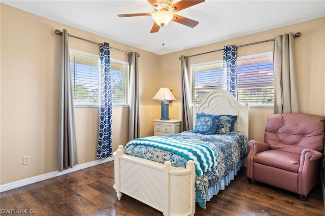 bedroom featuring ceiling fan, dark wood-type flooring, and multiple windows