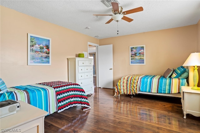 bedroom featuring ceiling fan, dark wood-type flooring, and a textured ceiling