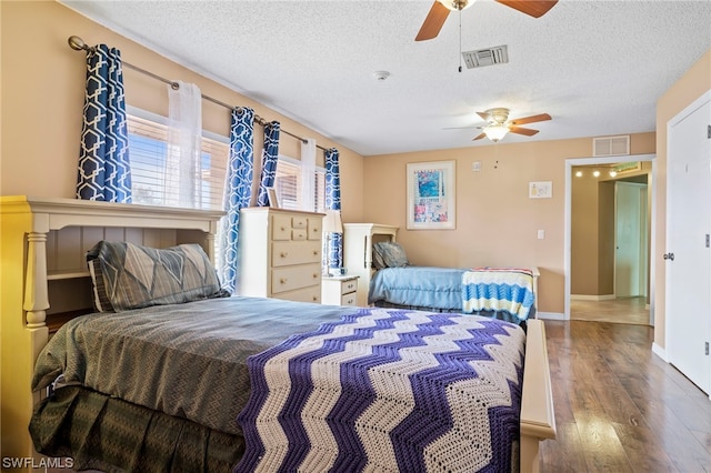 bedroom featuring hardwood / wood-style flooring, ceiling fan, and a textured ceiling