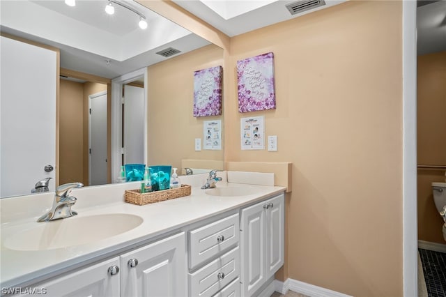 bathroom featuring double vanity and toilet