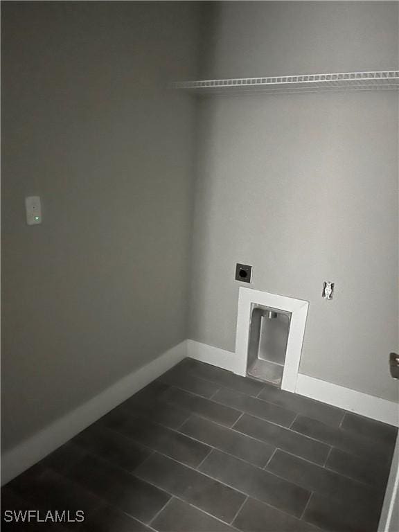 laundry area featuring electric dryer hookup and dark tile patterned flooring