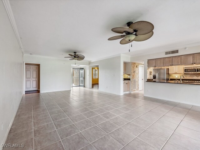 unfurnished living room with crown molding, light tile patterned flooring, and ceiling fan