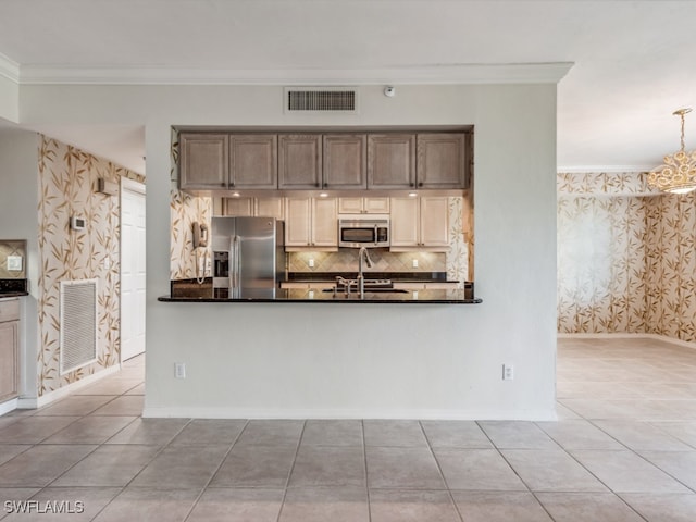 kitchen with backsplash, ornamental molding, stainless steel appliances, a chandelier, and tile patterned flooring