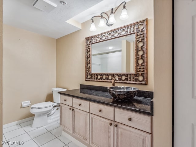 bathroom featuring tile patterned flooring, vanity, toilet, and walk in shower