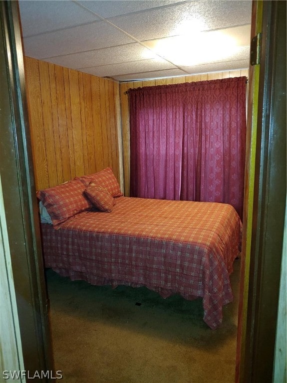 bedroom featuring wood walls and carpet flooring