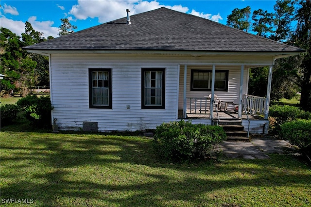 back of house featuring a porch and a lawn