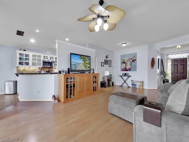 living room with ceiling fan and light hardwood / wood-style flooring