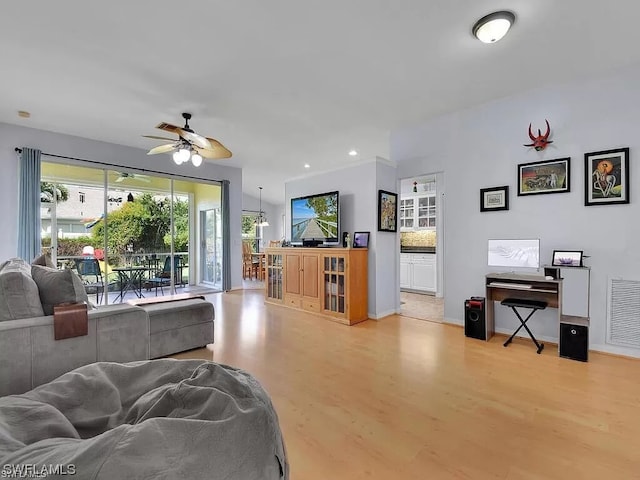 living room featuring light hardwood / wood-style floors and ceiling fan