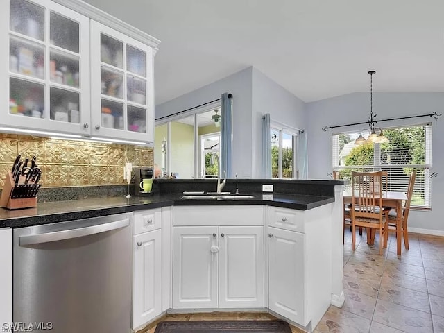 kitchen with white cabinetry, backsplash, an inviting chandelier, light tile floors, and stainless steel dishwasher