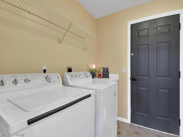 washroom with hookup for an electric dryer, independent washer and dryer, and light tile flooring