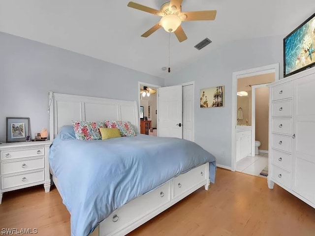 tiled bedroom with a closet, connected bathroom, ceiling fan, and vaulted ceiling